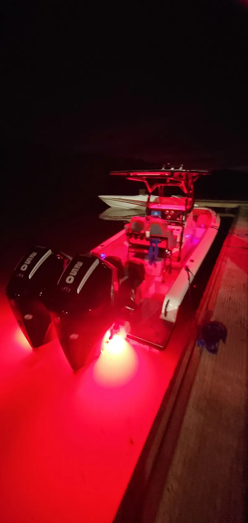 Slide: The Image of 2025 Concept Boats 27' CC illuminated with red lights at night. - 3