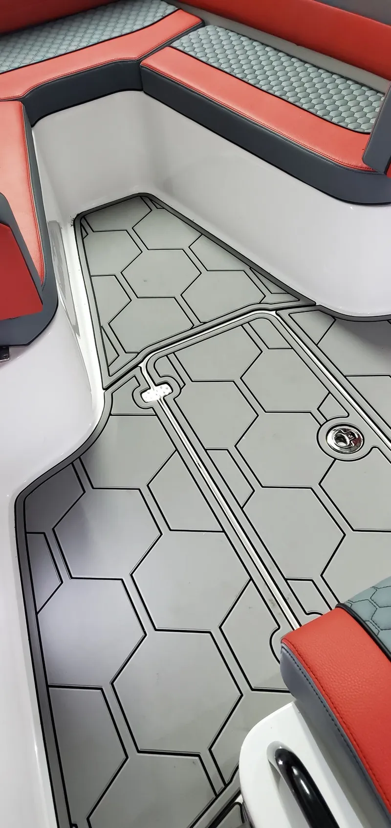 Slide: The Image of 2025 Concept Boats 27' CC interior with modern hexagonal flooring and red seating. - 6