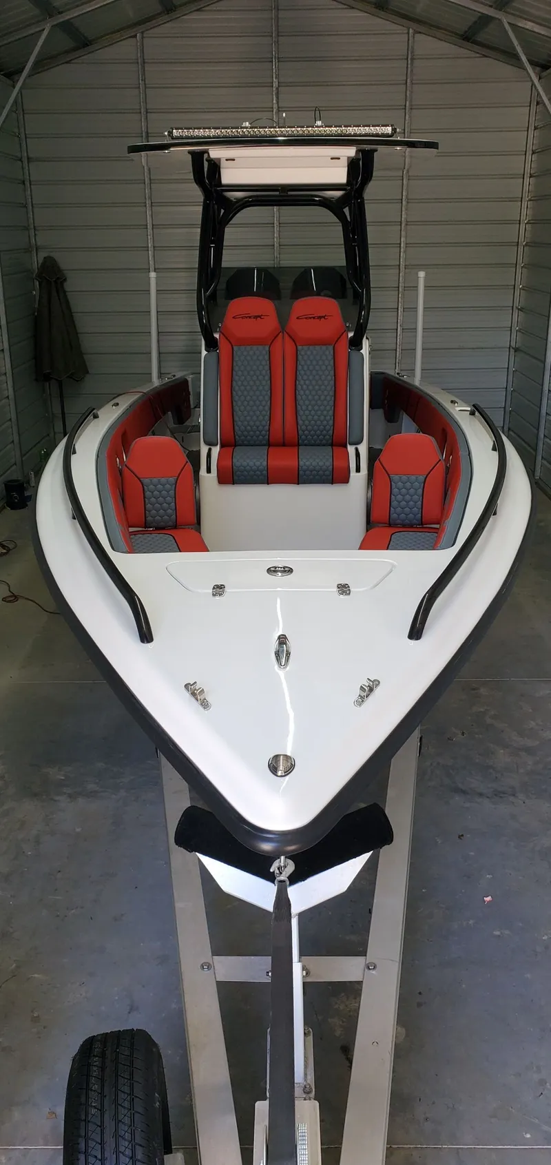 Slide: The Image of 2025 Concept Boats 27' CC with red and gray seating in a garage. - 7