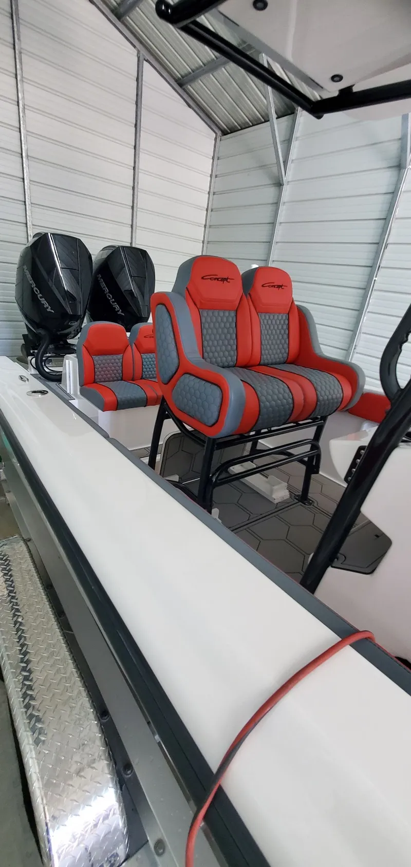 Slide: The Image of 2025 Concept Boats 27' CC with red and gray seating, dual Mercury engines in a metal shed. - 9
