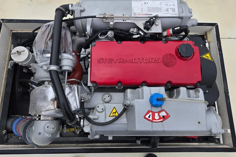 Slide: The Image of 1964 Whiticar 24 engine with Steyr Motors branding, featuring a red cover and various components. - 15