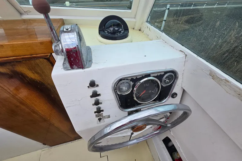 Slide: The Image of 1964 Whiticar 24 boat dashboard with steering wheel, throttle, and compass. - 16