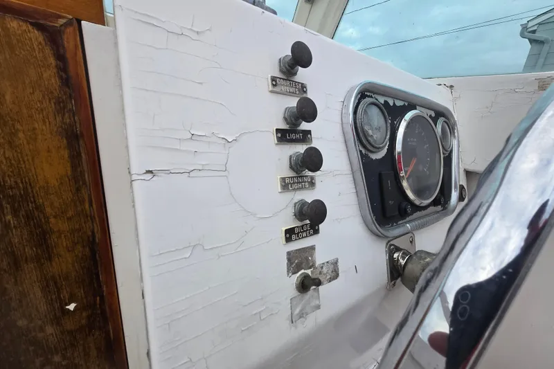 Slide: The Image of 1964 Whiticar 24 boat dashboard with vintage controls and gauges, showing wear and age. - 18