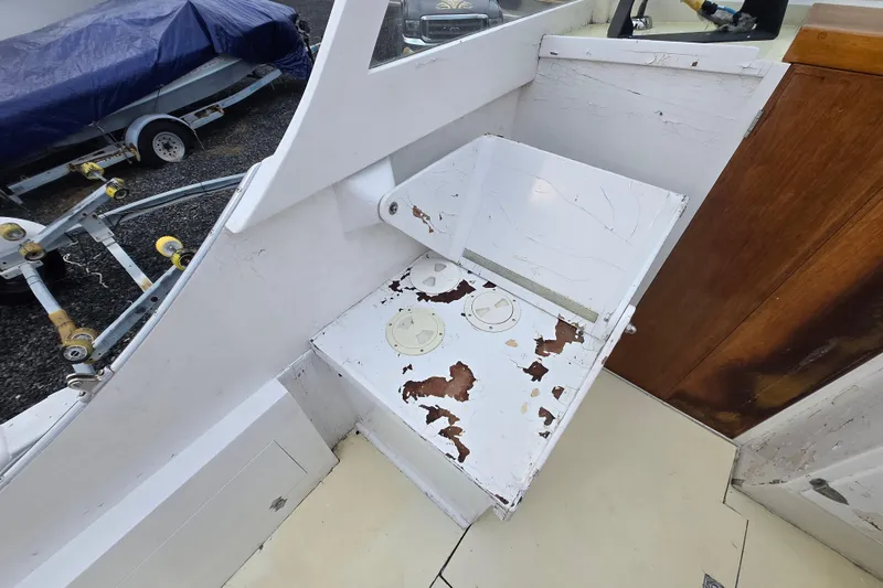 Slide: The Image of 1964 Whiticar 24 boat interior with worn white paint and wooden accents. - 19