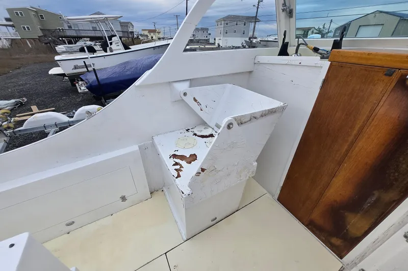 Slide: The Image of 1964 Whiticar 24 boat interior with weathered white seating and wooden cabinet. - 22