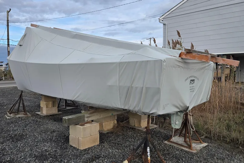 Slide: The Image of 1964 Whiticar 24 boat covered and elevated on blocks outdoors. - 24