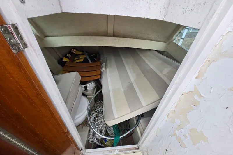 Slide: The Image of Interior of a 1964 Whiticar 24 boat with storage items and striped mattress. - 36