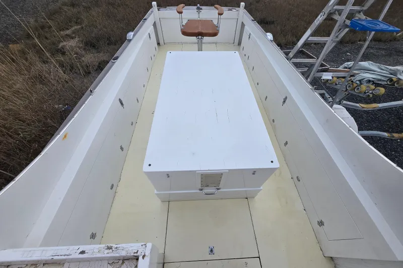 Slide: The Image of 1964 Whiticar 24 boat interior with white deck and central storage box. - 4