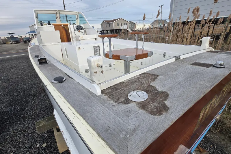 Slide: The Image of 1964 Whiticar 24 boat with wooden deck, docked near coastal homes. - 5