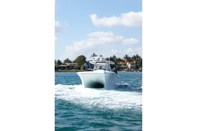Slide: The Image of 2026 Front Runner 35 Catamaran cruising on blue water near coastal homes. - 3