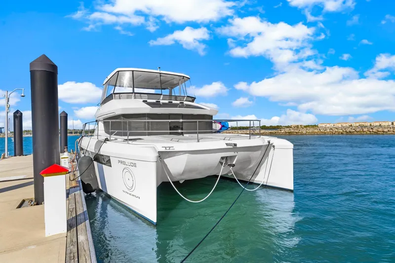 Slide: The Image of 2024 Leopard 46 Powercat yacht docked at marina under clear blue sky. - 12