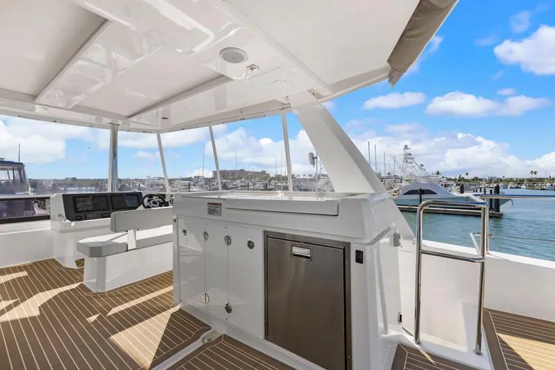 Slide: The Image of 2024 Leopard 46 Powercat yacht interior with helm, cabinetry, and ocean view. - 28