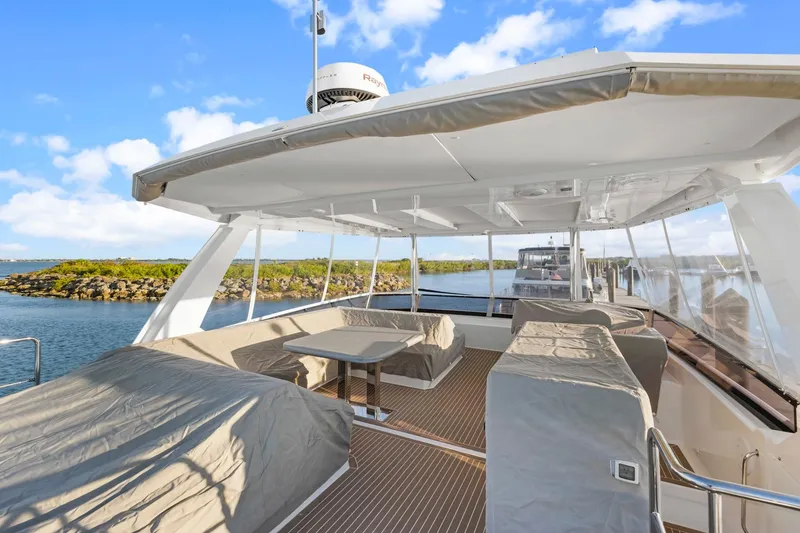 Slide: The Image of 2024 Leopard 46 Powercat yacht deck with covered seating, scenic water view. - 31