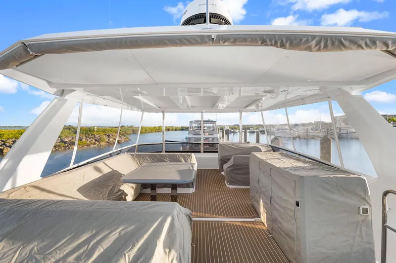 Slide: The Image of Spacious deck of 2024 Leopard 46 Powercat yacht with covered seating and scenic marina view. - 32