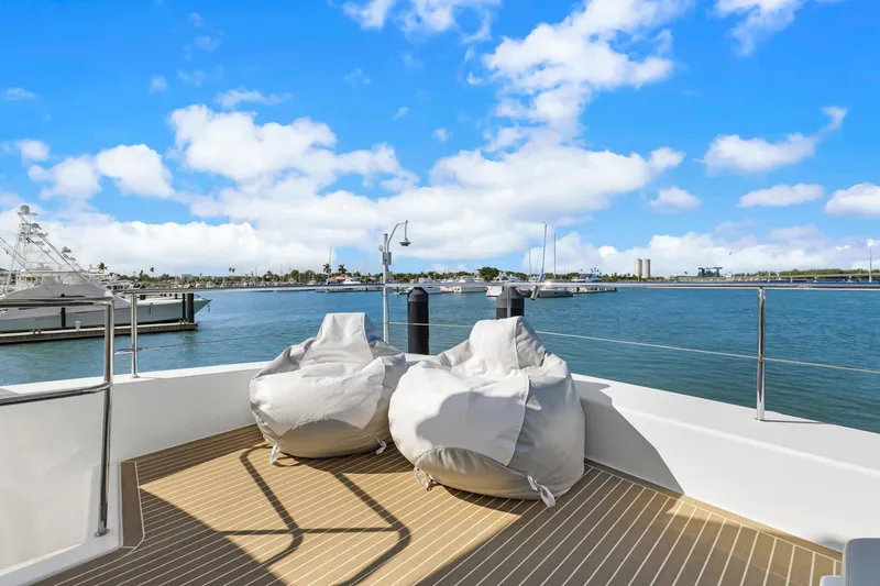 Slide: The Image of 2024 Leopard 46 Powercat deck with bean bag chairs, overlooking marina and blue sky. - 34