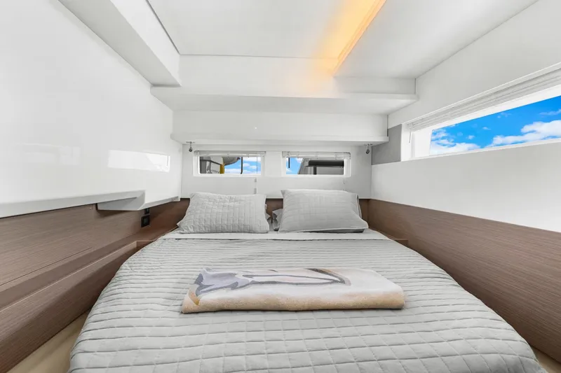 Slide: The Image of 2024 Leopard 46 Powercat cabin interior with bed, pillows, and window view. - 63