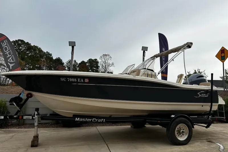 Slide: The Image of 2022 Scout 195 Sport Dorado boat on a MasterCraft trailer, parked outdoors. - 6