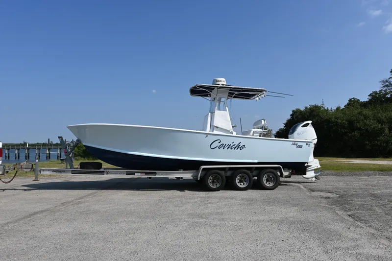 Slide: The Image of 1983 SeaVee 260B boat on trailer, named "Ceviche," under clear blue sky. - 16