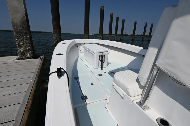 Slide: The Image of 1983 SeaVee 260B boat docked, showcasing spacious deck and seating area. - 6