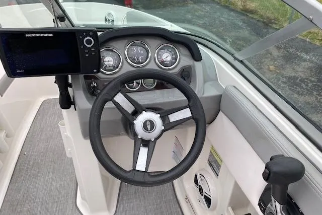 Slide: The Image of 2019 Chaparral 19 H2O Sport boat dashboard with steering wheel and navigation system. - 2