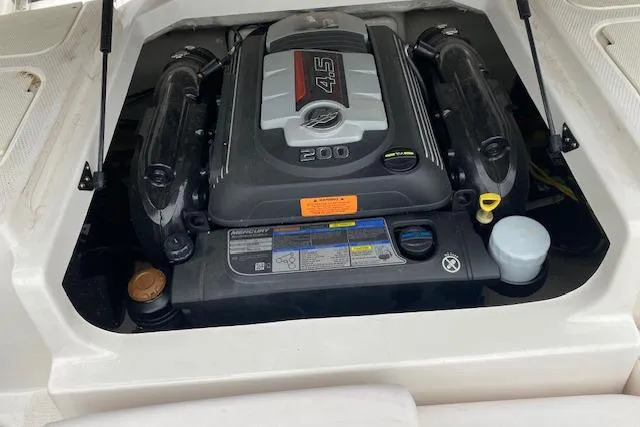 Slide: The Image of 2019 Chaparral 19 H2O Sport engine compartment with visible 4.5L 200 HP engine. - 9