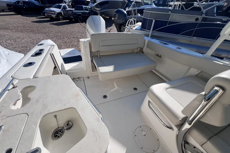 Slide: The Image of 2020 Boston Whaler 230 Vantage boat interior with seating and sink, parked among other boats. - 12