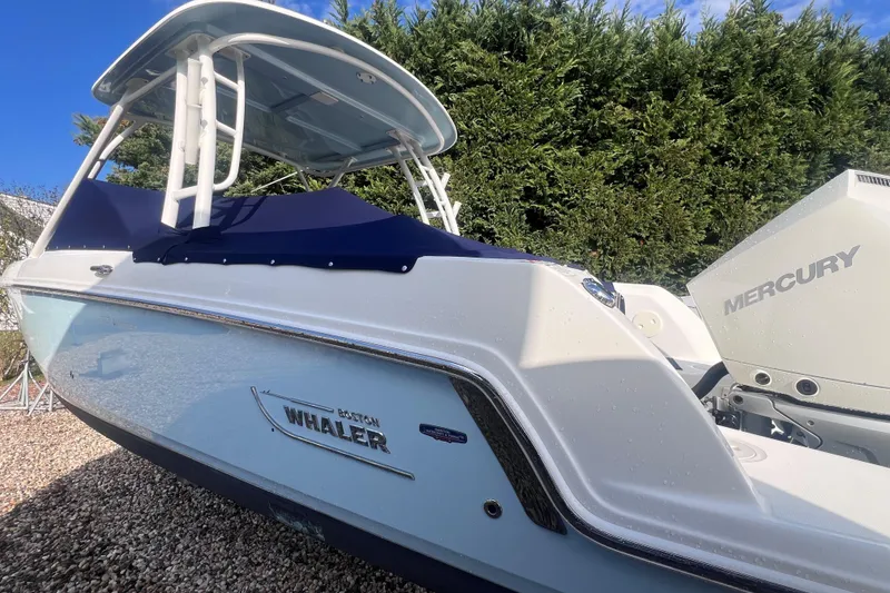 Slide: The Image of 2020 Boston Whaler 230 Vantage boat with Mercury engine, parked outdoors. - 4
