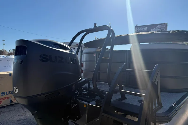 Slide: The Image of 2026 Bentley Pontoons Legacy 223 Navigator with Suzuki outboard motor in sunlight. - 4