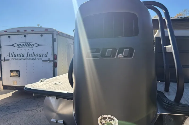 Slide: The Image of 2026 Bentley Pontoons Legacy 223 Navigator with 200 HP engine, parked near trailer. - 5