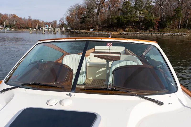 Slide: The Image of 2006 Hinckley Talaria 29 R boat with elegant seating, docked on a calm lake. - 13