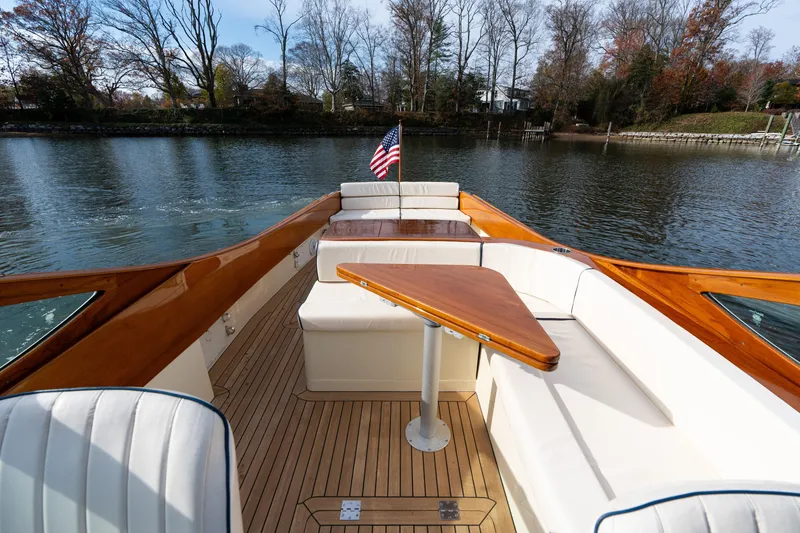 Slide: The Image of 2006 Hinckley Talaria 29 R boat interior with elegant seating and wooden accents on a serene lake. - 15