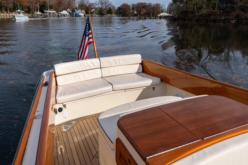 Slide: The Image of 2006 Hinckley Talaria 29 R boat with American flag, elegant seating, and wooden deck. - 16