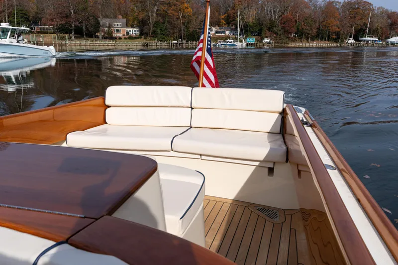 Slide: The Image of 2006 Hinckley Talaria 29 R boat with elegant seating and American flag on calm water. - 17