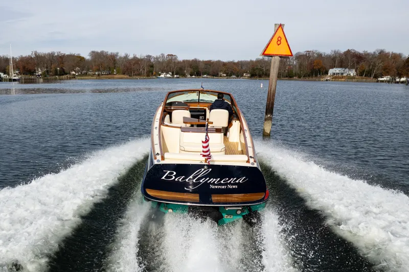 Slide: The Image of 2006 Hinckley Talaria 29 R boat cruising on a calm lake with wake trails. - 2