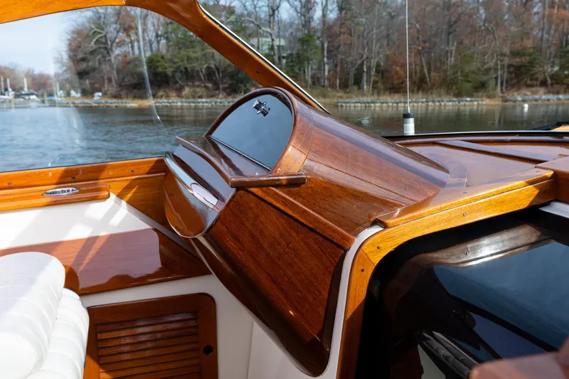 Slide: The Image of 2006 Hinckley Talaria 29 R interior with polished wood dashboard and white seating. - 27