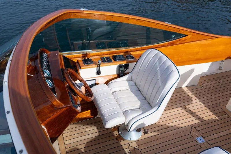 Slide: The Image of 2006 Hinckley Talaria 29 R boat cockpit with wooden dashboard and white leather seat. - 29