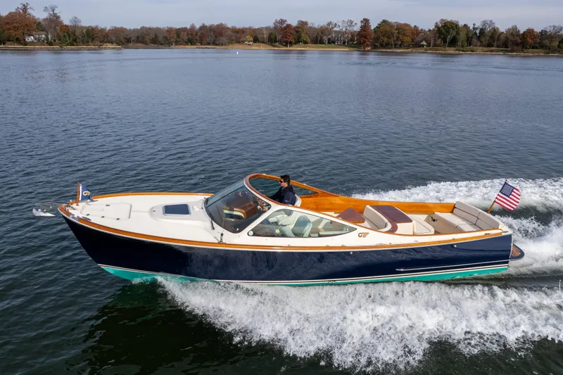 Slide: The Image of 2006 Hinckley Talaria 29 R cruising on a calm lake with American flag. - 3