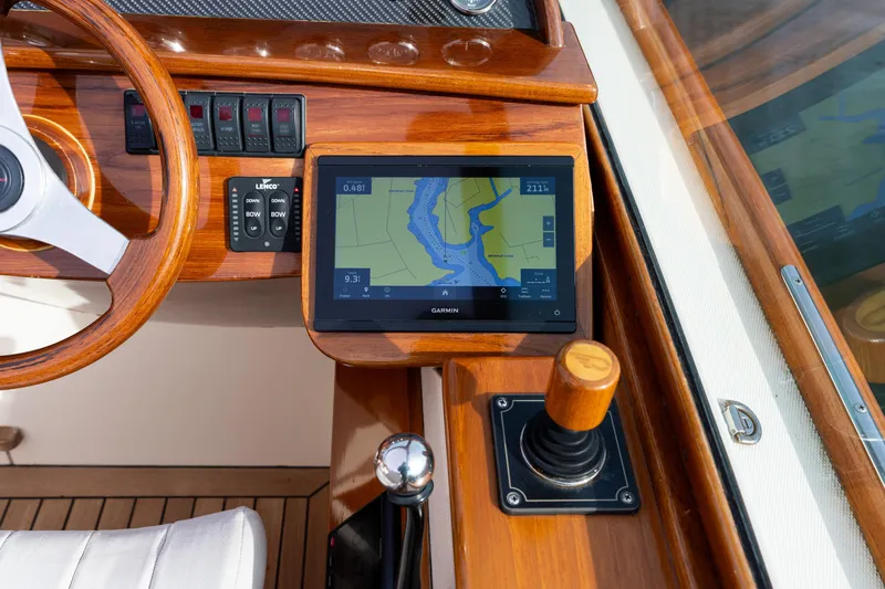 Slide: The Image of 2006 Hinckley Talaria 29 R dashboard with Garmin navigation and wooden steering wheel. - 34
