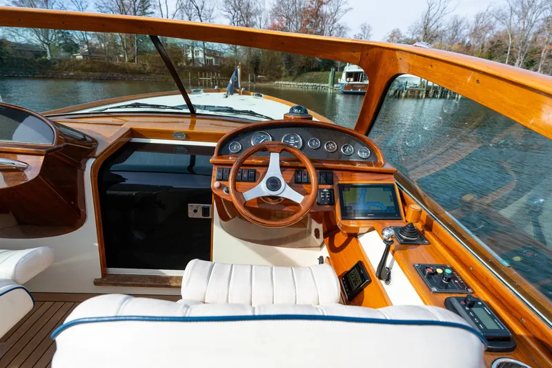 Slide: The Image of Interior of a 2006 Hinckley Talaria 29 R boat with wooden dashboard and steering wheel. - 35