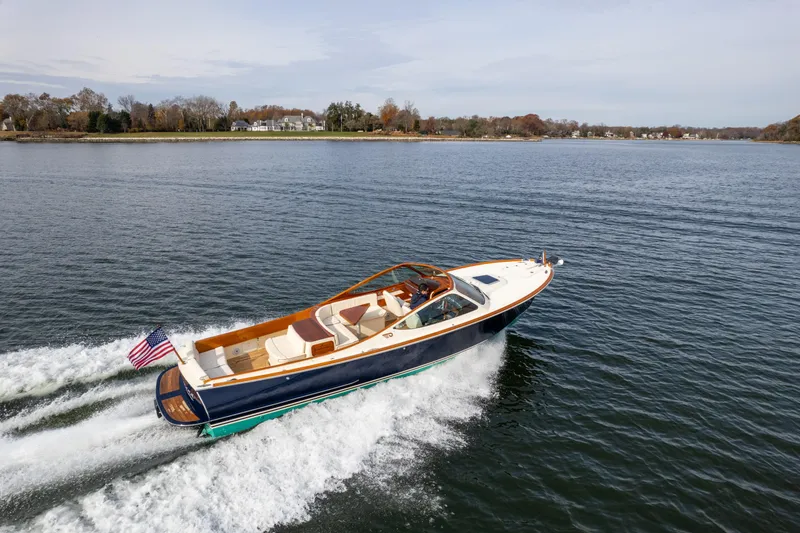 Slide: The Image of 2006 Hinckley Talaria 29 R cruising on a serene lake with scenic shoreline. - 5