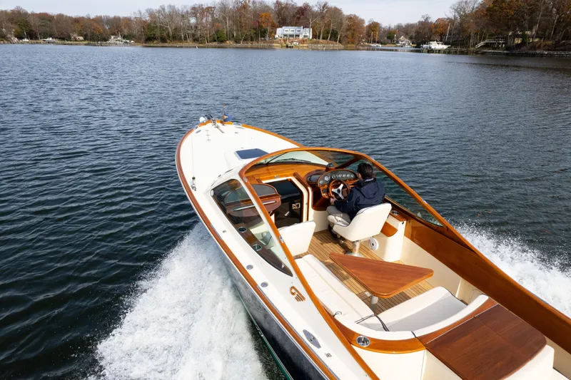 Slide: The Image of 2006 Hinckley Talaria 29 R cruising on a serene lake with autumn trees. - 8