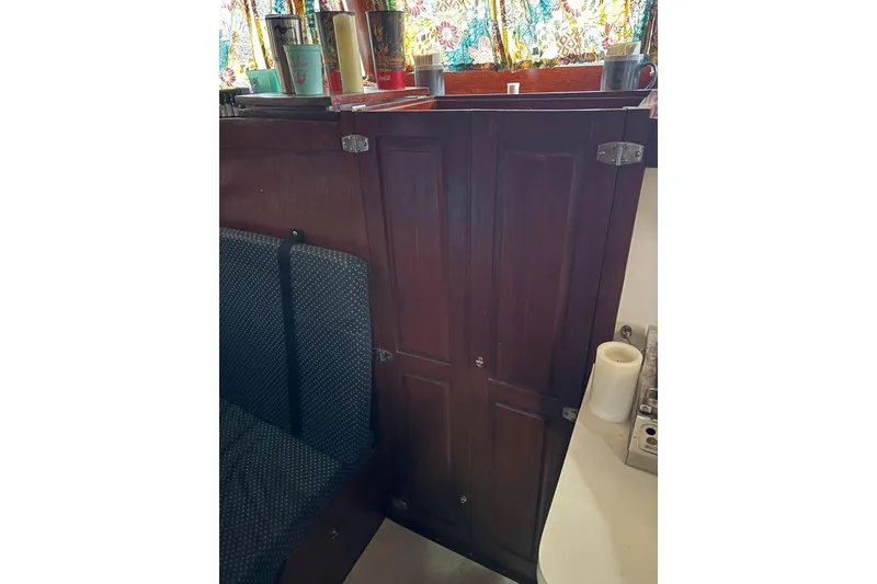 Slide: The Image of Wooden cabinet in 1987 Custom Cedar Craft interior with colorful curtains and countertop items. - 26