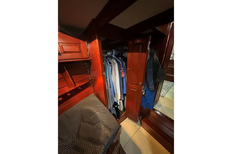 Slide: The Image of Wooden closet interior with hanging clothes, part of a 1987 Custom Cedar Craft. - 31