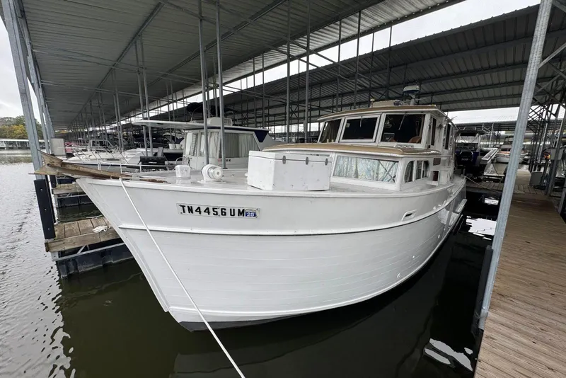 Slide: The Image of White 1987 Custom Cedar Craft boat docked in a covered marina. - 4