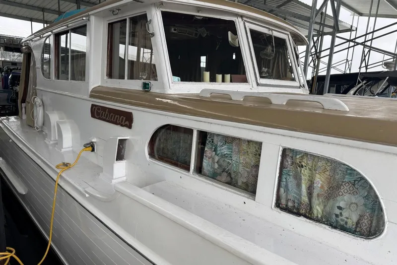 Slide: The Image of 1987 Custom Cedar Craft boat with floral curtains, docked under a metal canopy. - 9