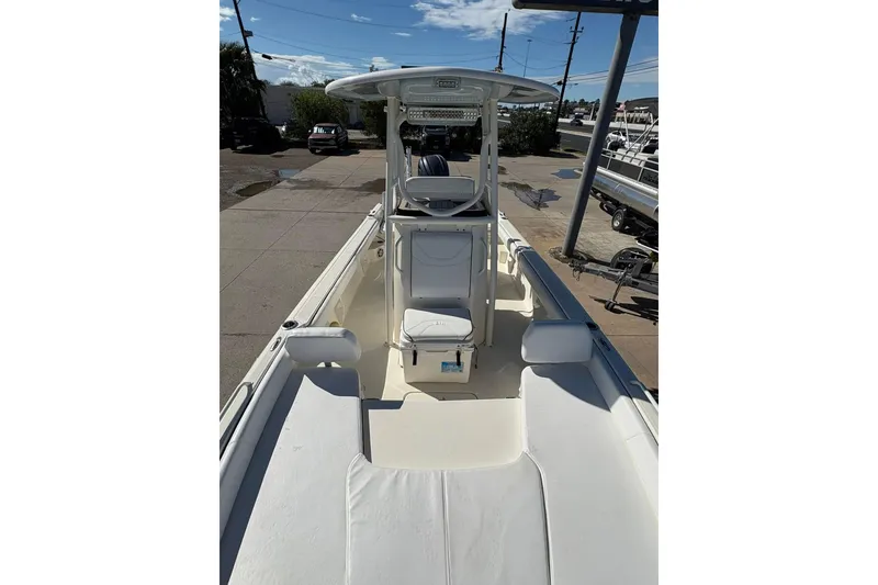Slide: The Image of 2023 Skeeter SX2550 Family boat, spacious deck, white seating, clear sky background. - 21