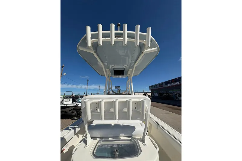 Slide: The Image of 2023 Skeeter SX2550 Family boat with rod holders and seating, under clear blue sky. - 6