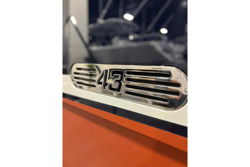 Slide: The Image of Close-up of 2026 Front Runner 43 HTX Catamaran emblem on orange hull. - 15