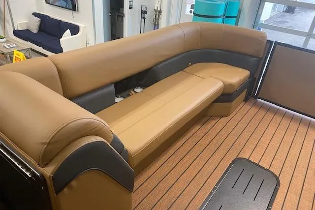 Slide: The Image of 2026 Bentley Pontoons Elite 253 Swingback interior with tan seating and wood-style flooring. - 10