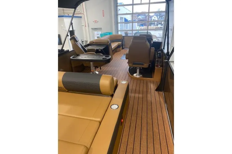 Slide: The Image of 2026 Bentley Pontoons Elite 253 Swingback interior with luxurious seating and wood flooring. - 18